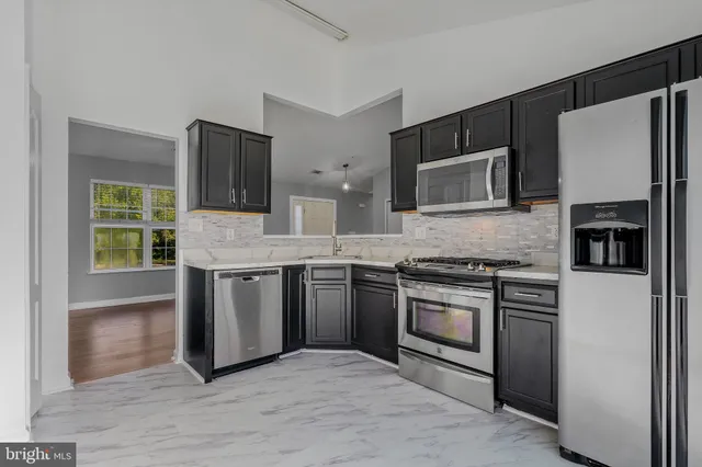 a kitchen with stainless steel appliances granite countertop a stove a microwave and a refrigerator