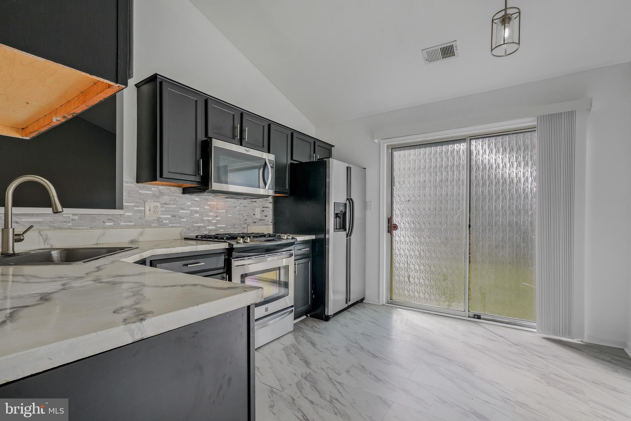 9503 Fletcher Avenue Clinton, MD 20735 - Photo 8 of 27 a kitchen with stainless steel appliances granite countertop a sink stove and refrigerator