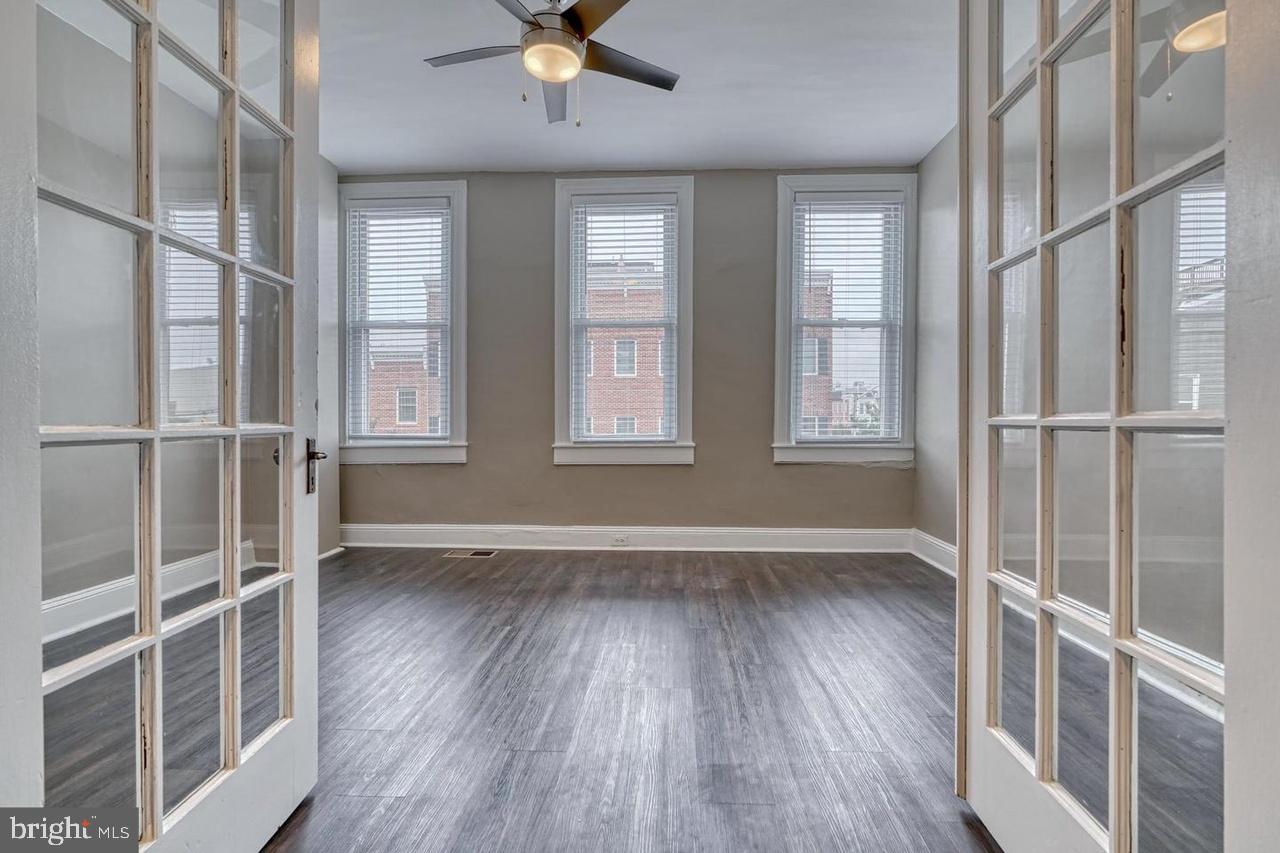 1503 South Charles Street, Unit 2 Baltimore, MD 21230 - Photo 6 of 9 an empty room with wooden floor and windows