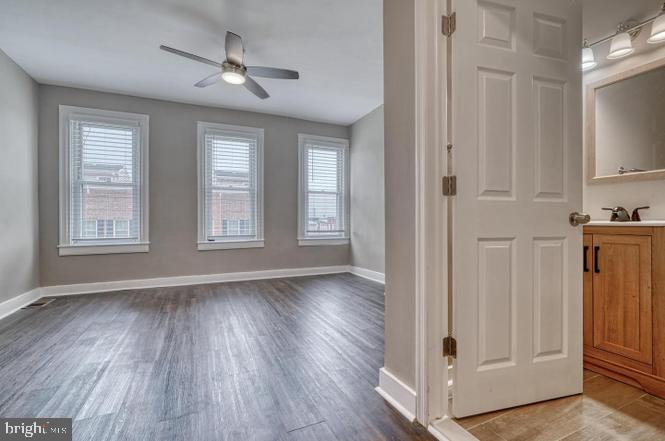 1503 South Charles Street, Unit 2 Baltimore, MD 21230 - Photo 7 of 9 a view of an empty room with a window and wooden floor