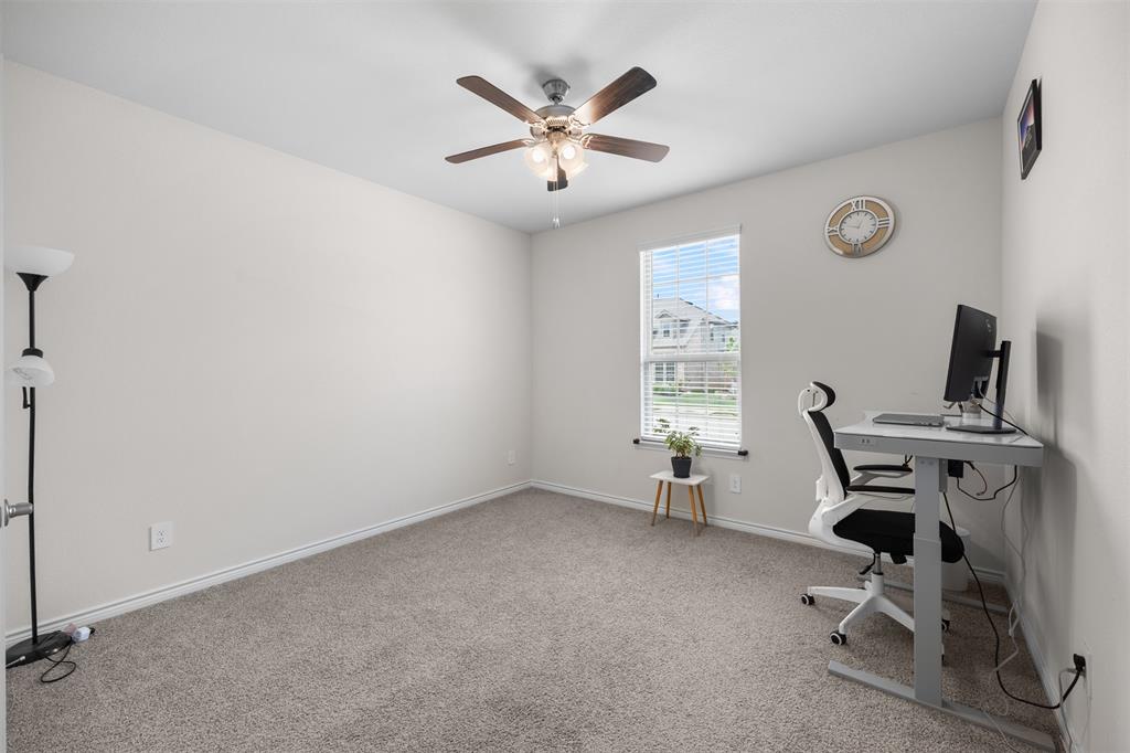 3808 High Country Road Aubrey, TX 76227 - Photo 9 of 36 Neutral wall paint in a flexible room featuring a ceiling fan with integrated lighting, a single window with horizontal blinds, and grey carpet flooring