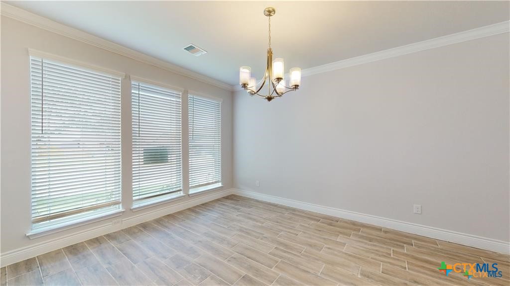 8601 Ridge Crest Drive Killeen, TX 76542 - Photo 28 of 30 a view of a livingroom with a chandelier wooden floor and windows