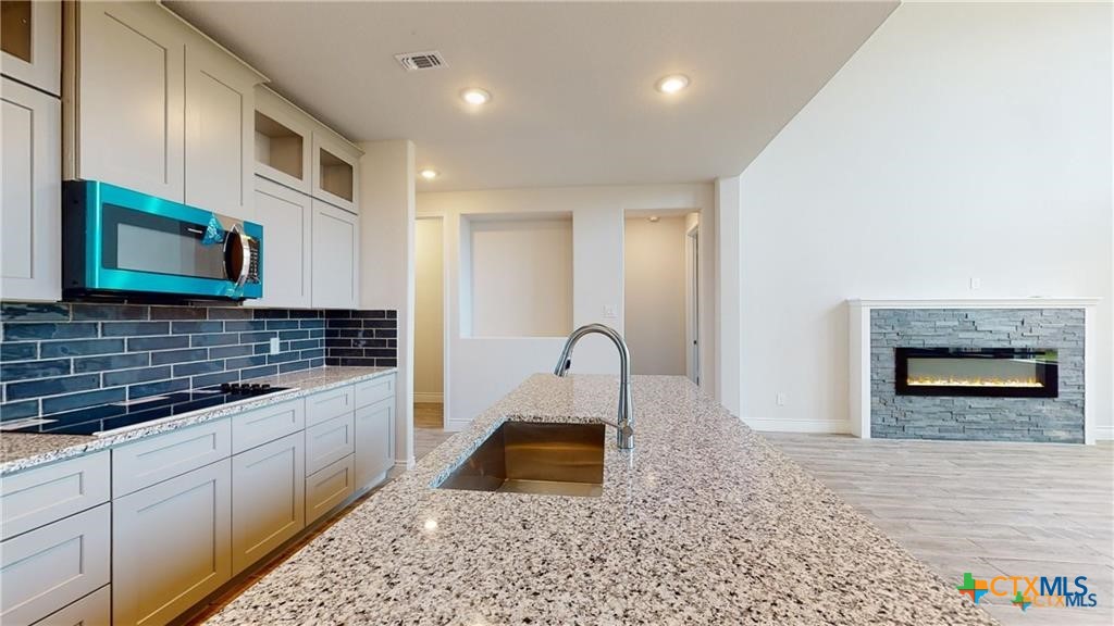 8601 Ridge Crest Drive Killeen, TX 76542 - Photo 6 of 30 a kitchen with stainless steel appliances granite countertop a stove a sink and a microwave
