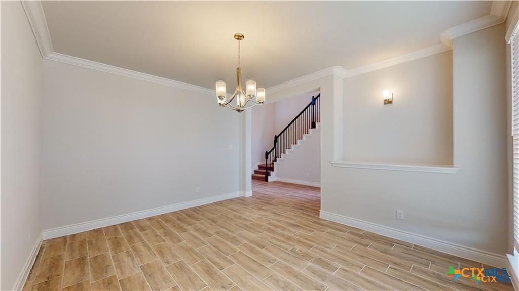 8601 Ridge Crest Drive Killeen, TX 76542 - Photo 8 of 30 wooden floor in an empty room with a chandelier