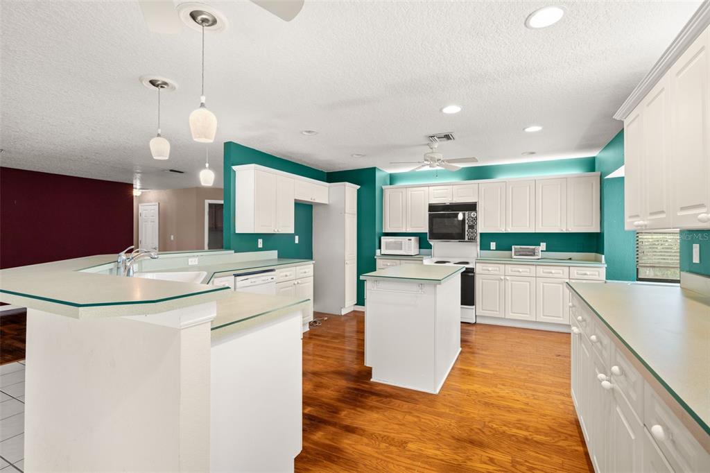 18132 Oakdale Road Odessa, FL 33556 - Photo 15 of 40 a kitchen with stainless steel appliances kitchen island granite countertop a stove a sink and a refrigerator