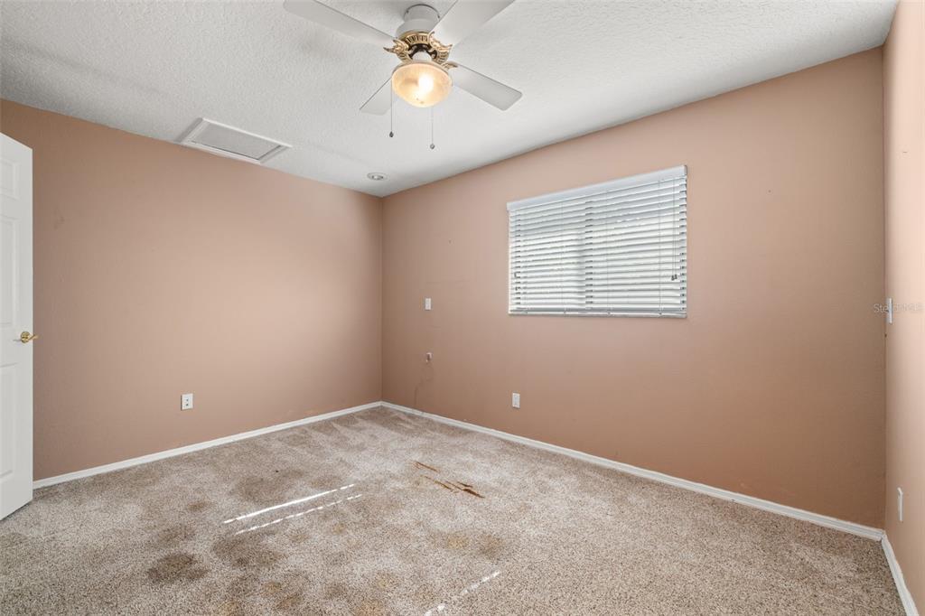 18132 Oakdale Road Odessa, FL 33556 - Photo 21 of 40 an empty room with a chandelier fan and windows