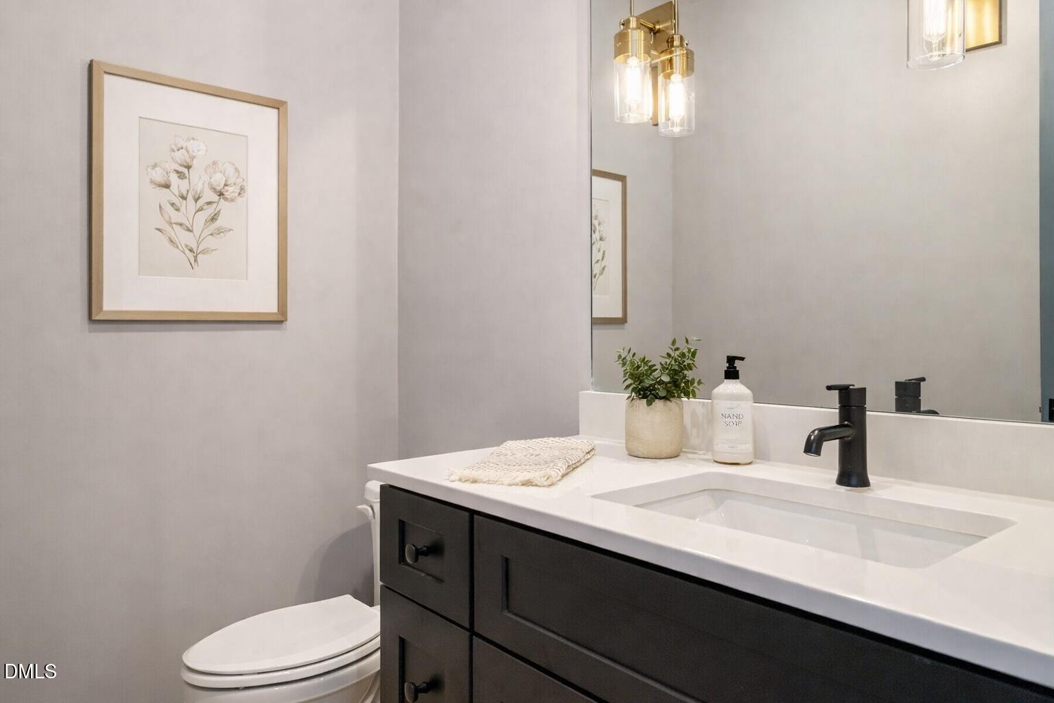 1525 Urban Trace Lane Raleigh, NC 27608 - Photo 13 of 33 a bathroom with a sink a toilet and mirror