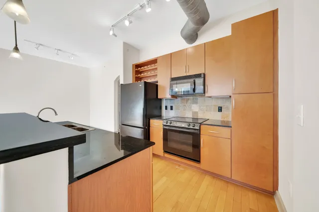 a kitchen with stainless steel appliances a refrigerator sink and stove