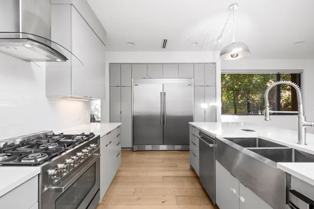 a kitchen with stainless steel appliances granite countertop a sink stove and refrigerator