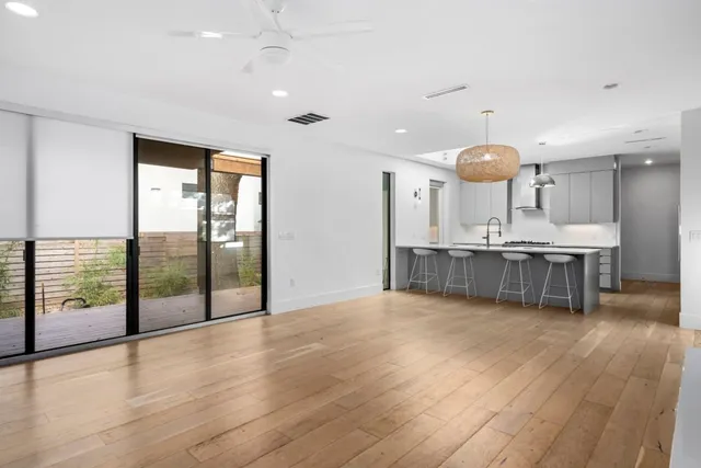 an empty room with wooden floor and outdoor view