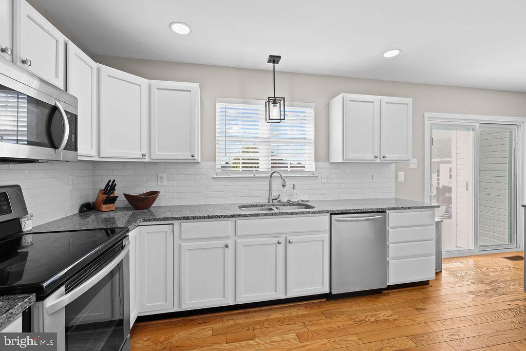 4445 Rolling Acres Drive Hurlock, MD 21643 - Photo 10 of 35 a kitchen with stainless steel appliances granite countertop a sink a stove a refrigerator and cabinets