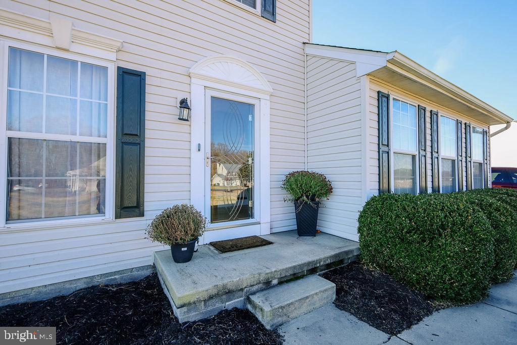 4445 Rolling Acres Drive Hurlock, MD 21643 - Photo 32 of 35 a house with potted plants in front of door