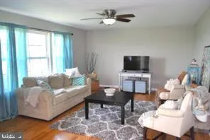 a living room with furniture a flat screen tv and a window