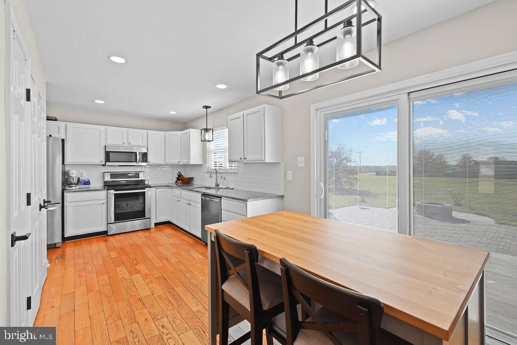 4445 Rolling Acres Drive Hurlock, MD 21643 - Photo 8 of 35 a kitchen with a table chairs refrigerator and cabinets