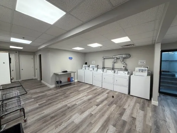 a large white kitchen with kitchen island a sink stainless steel appliances and cabinets
