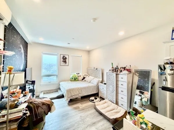 a spacious bedroom with a bed a couch and a bookshelf