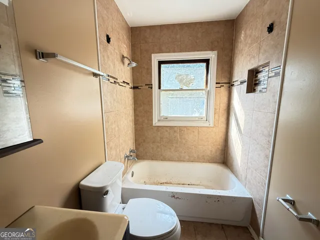 a bathroom with a toilet and a bathtub