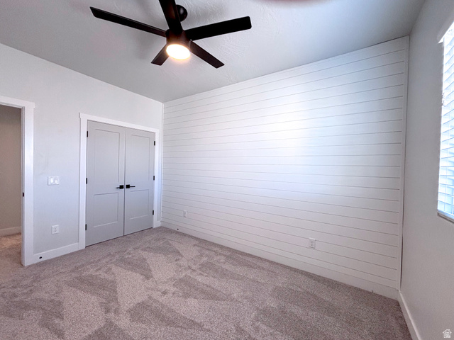 429 East Treasure Road Washington, UT 84780 - Photo 18 of 20 Room featuring a white shiplap accent wall, neutral carpeting, and a black ceiling fan with integrated lighting