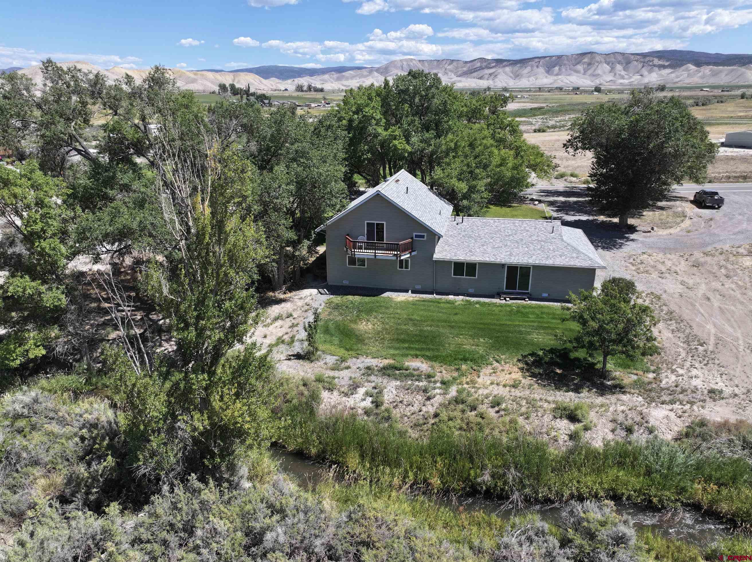 a aerial view of a house with a yard and a large tree