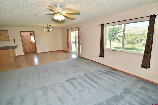 a view of n empty room with window and wooden floor