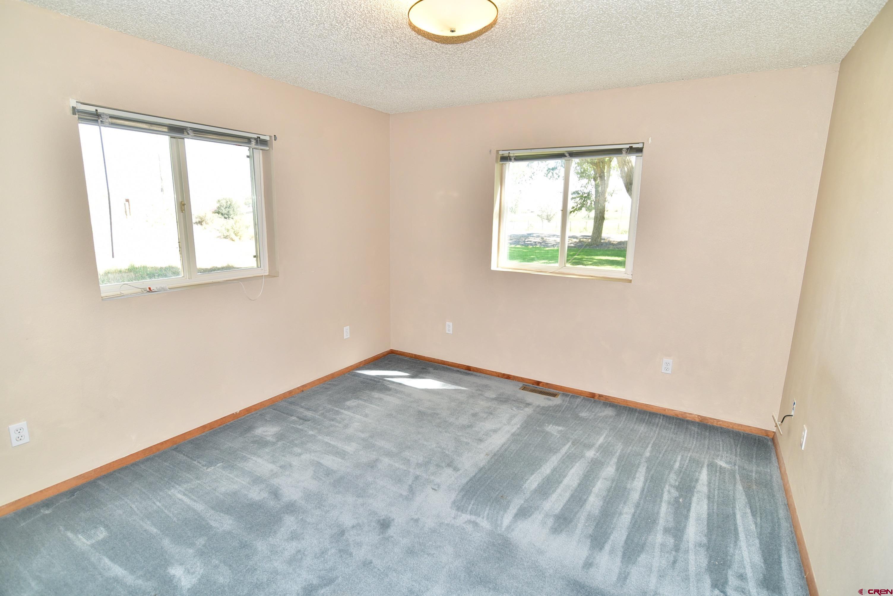 68600 Kinikin Road Montrose, CO 81403 - Photo 25 of 44 an empty room with wooden floor and windows