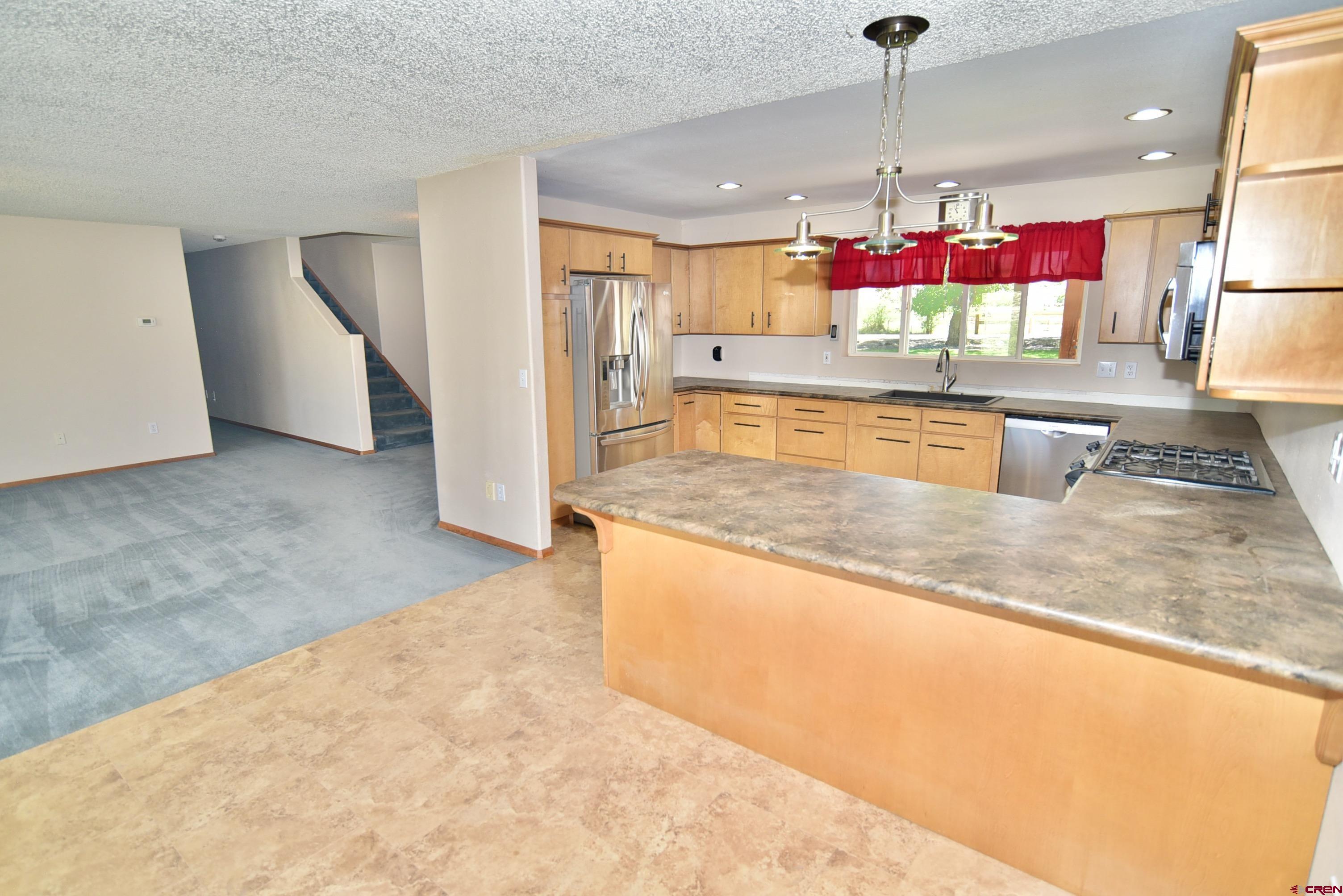 68600 Kinikin Road Montrose, CO 81403 - Photo 7 of 44 a kitchen with kitchen island granite countertop a stove and a sink