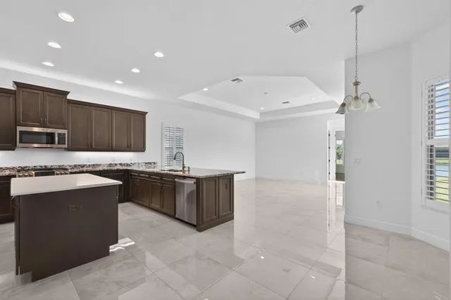 a kitchen with kitchen island granite countertop stainless steel appliances and a sink
