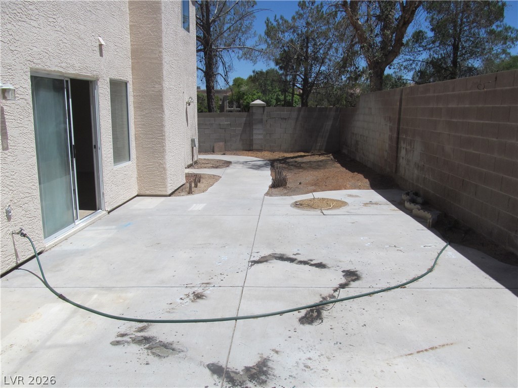 8701 Crescent Ridge Lane Las Vegas, NV 89134 - Photo 27 of 28 A spacious backyard patio awaits your landscaping vision, enclosed by sturdy block fencing.