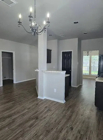 a view of a big room with wooden floor and windows