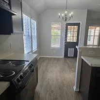 a kitchen that has a stove and a wooden floor