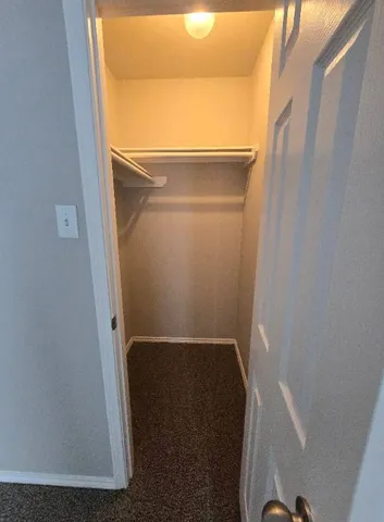 an empty room with wooden floor chandelier fan and windows