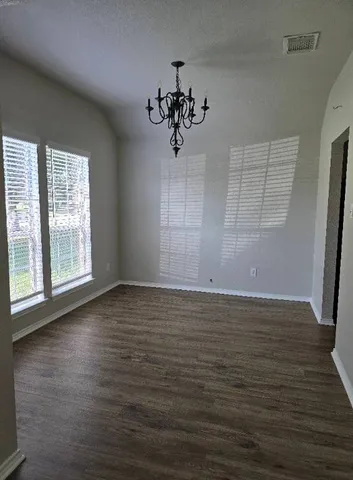 a view of a room with wooden floor and window