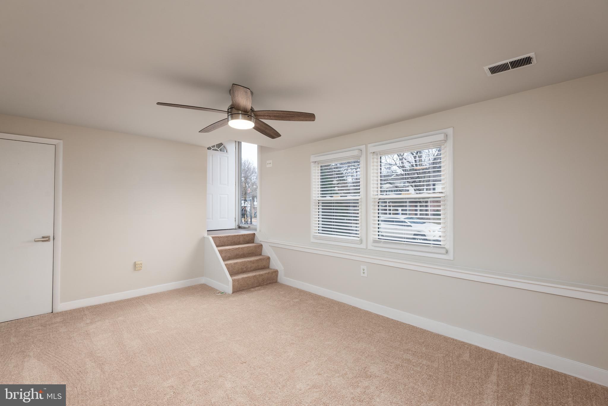 724 Chapelgate Drive Odenton, MD 21113 - Photo 11 of 26 an empty room with chandelier fan and windows