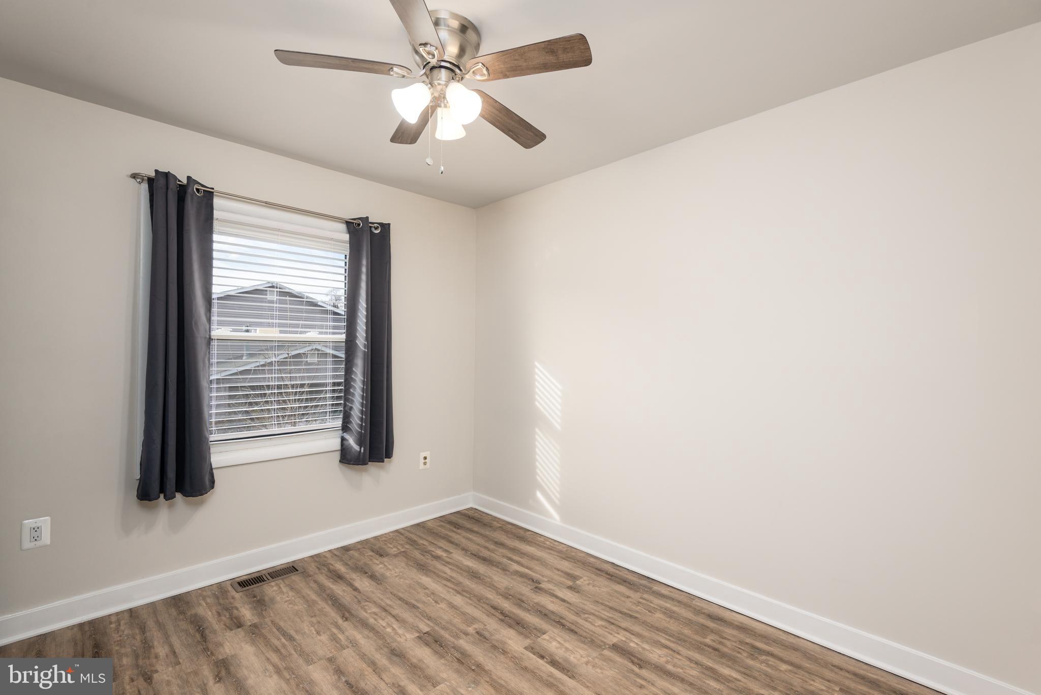 724 Chapelgate Drive Odenton, MD 21113 - Photo 13 of 26 an empty room with wooden floor fan and windows