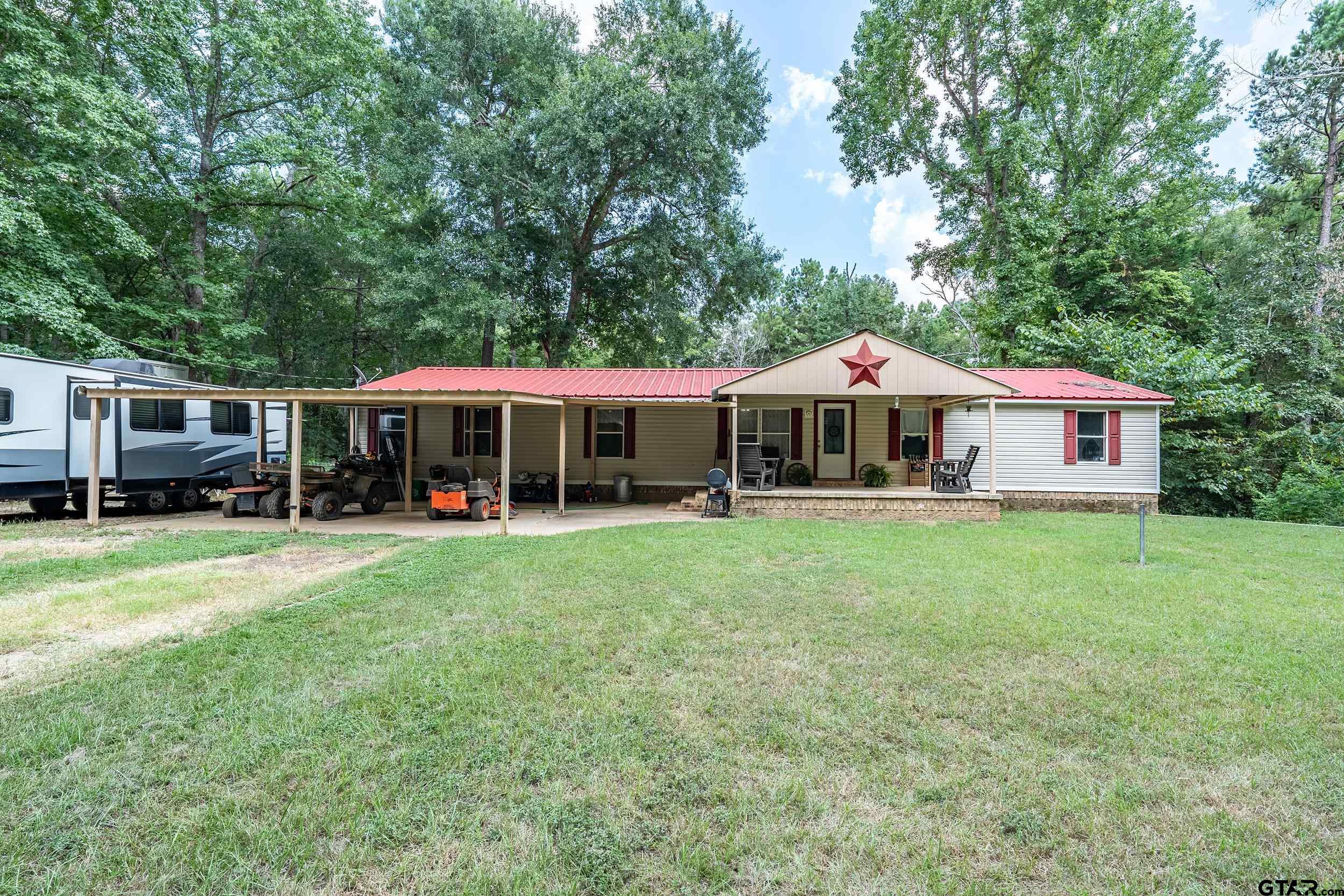 1655 County Road 2120 Rusk, TX 75785 - Photo 1 of 37 a front view of a house with a yard table and chairs