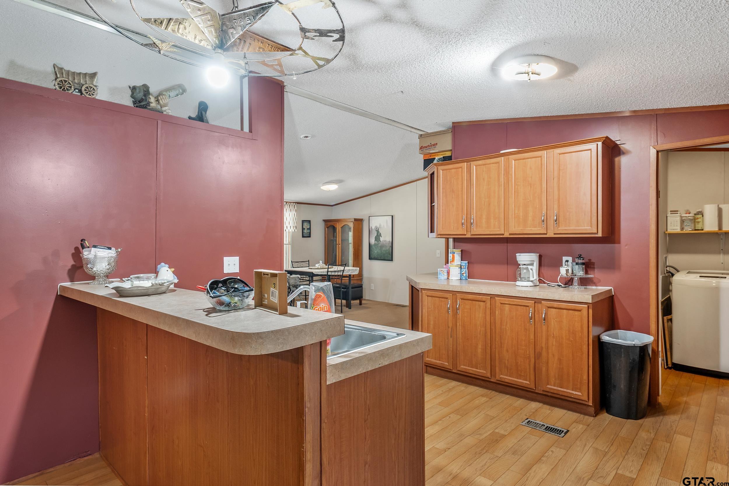1655 County Road 2120 Rusk, TX 75785 - Photo 20 of 37 a kitchen with a sink and wooden cabinets