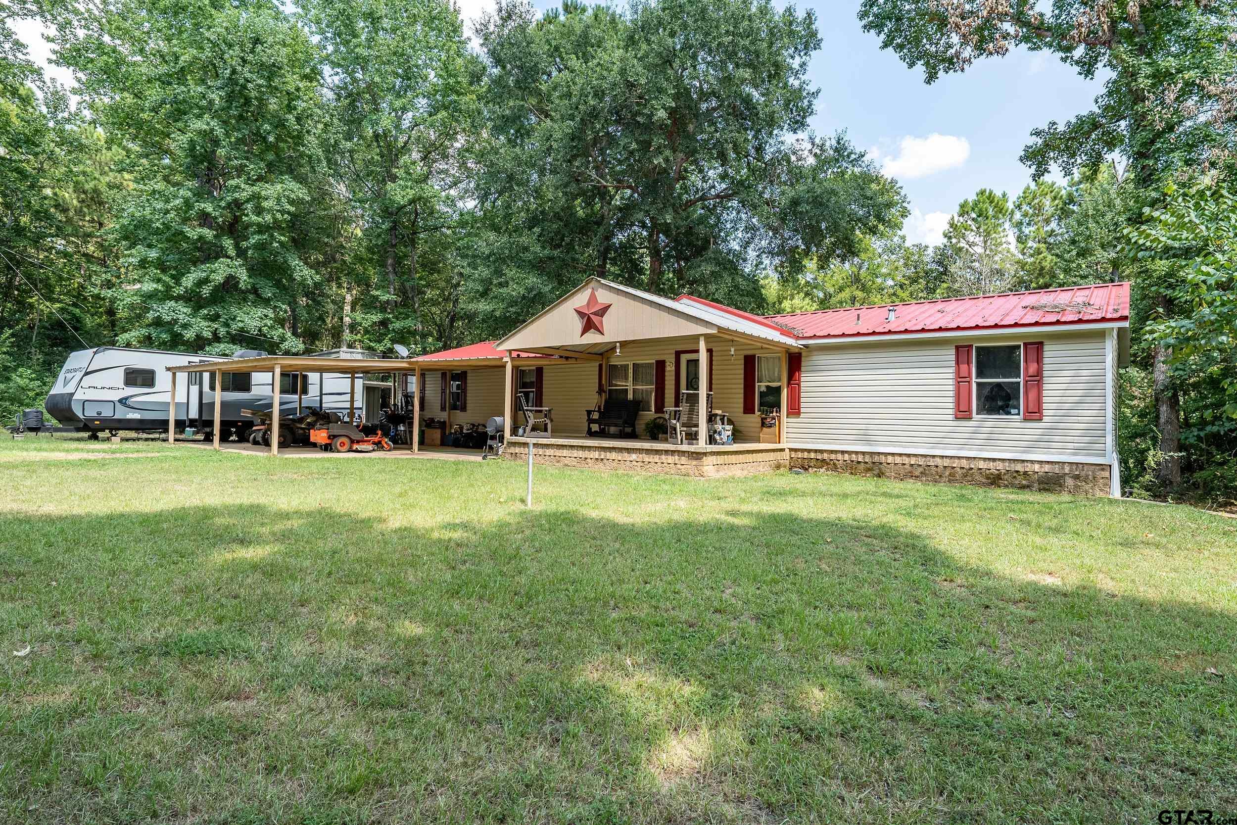 1655 County Road 2120 Rusk, TX 75785 - Photo 2 of 37 a front view of a house with a garden