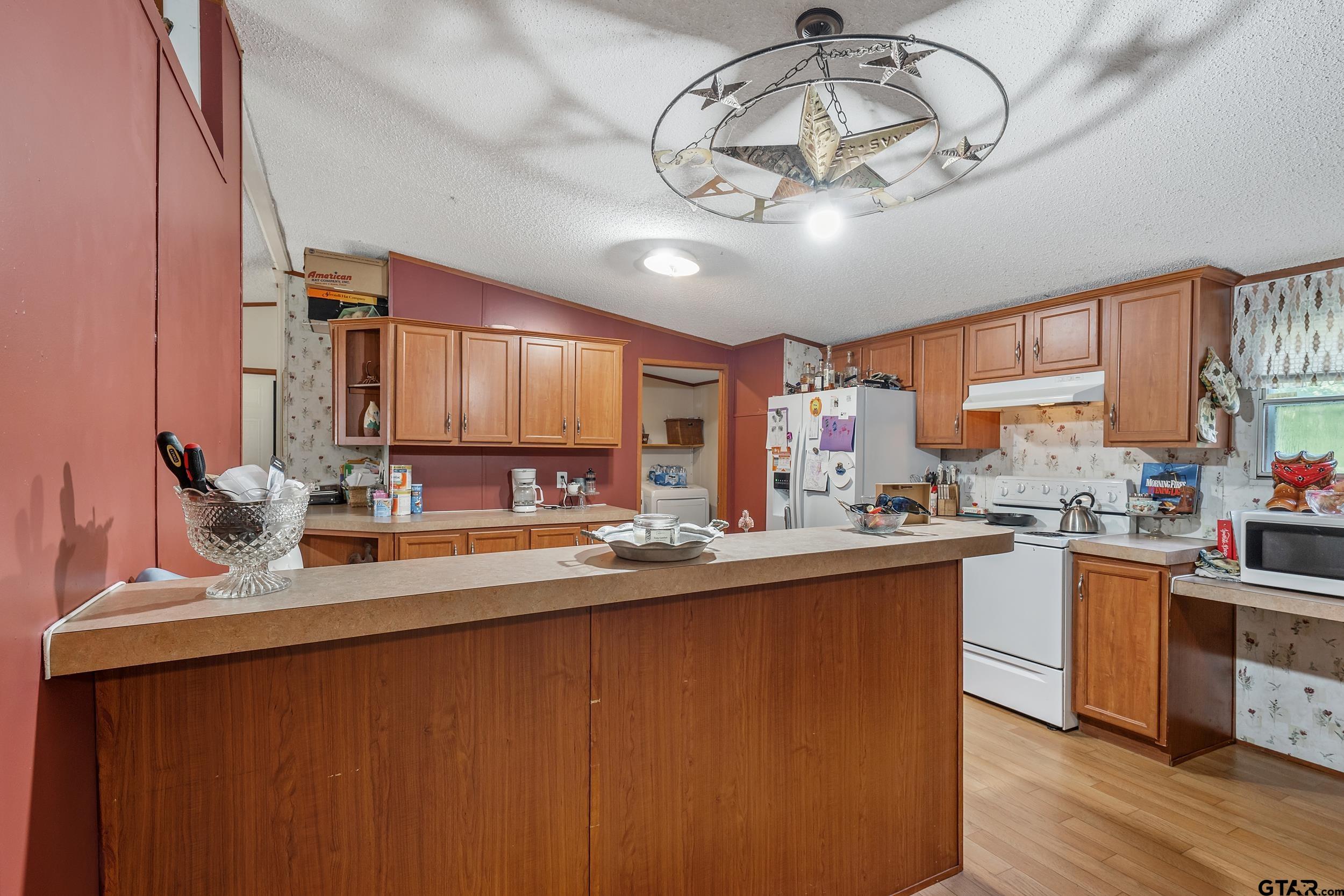1655 County Road 2120 Rusk, TX 75785 - Photo 30 of 37 a kitchen with stainless steel appliances a sink dishwasher a stove a refrigerator with wooden cabinets and floor