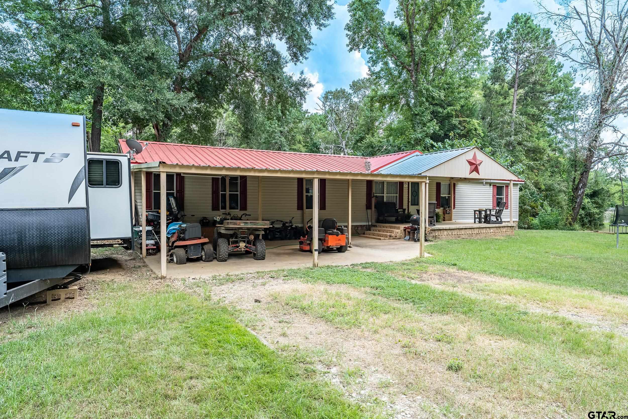 1655 County Road 2120 Rusk, TX 75785 - Photo 3 of 37 a patio with table and chairs under an umbrella