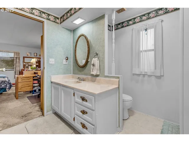 a bathroom with a sink a toilet and a mirror