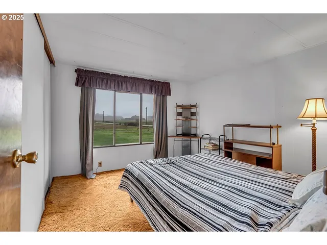 a bedroom with a bed and a large window