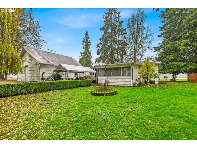 a view of a house with backyard and sitting area