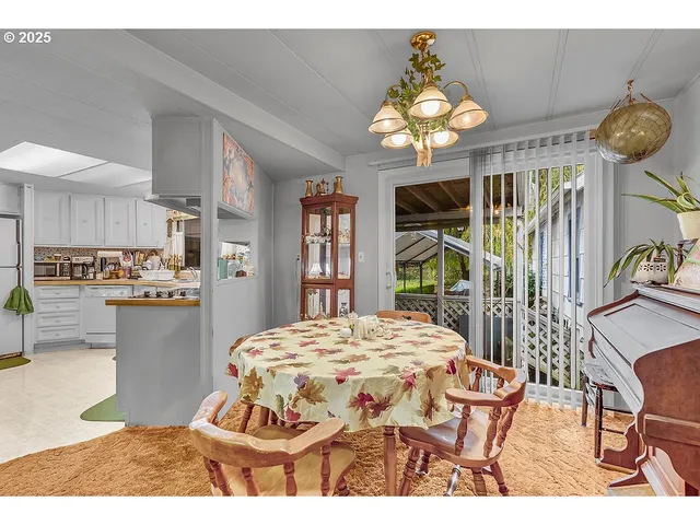 a dining room with wooden floor a chandelier a wooden table and chairs