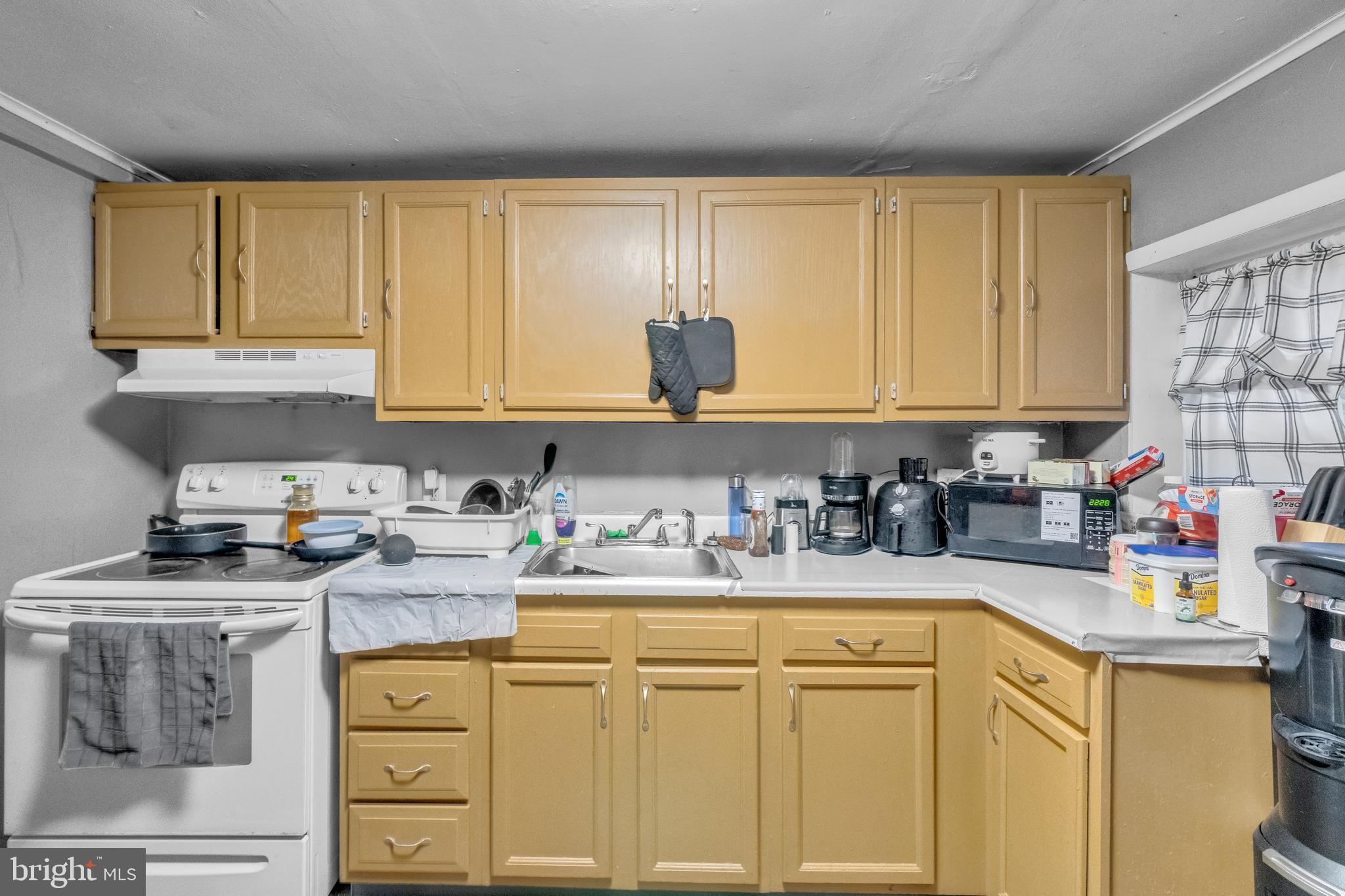 423 North Hall Street Allentown, PA 18102 - Photo 4 of 18 a kitchen with stainless steel appliances granite countertop a sink stove and cabinets