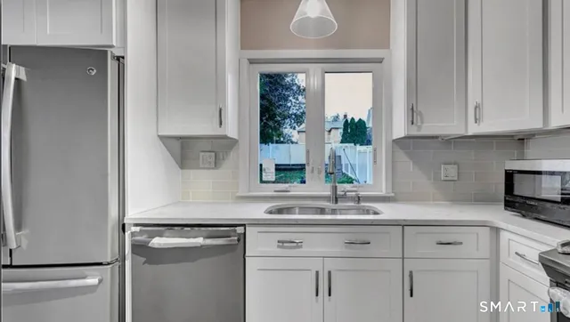 a kitchen with granite countertop white cabinets and a sink