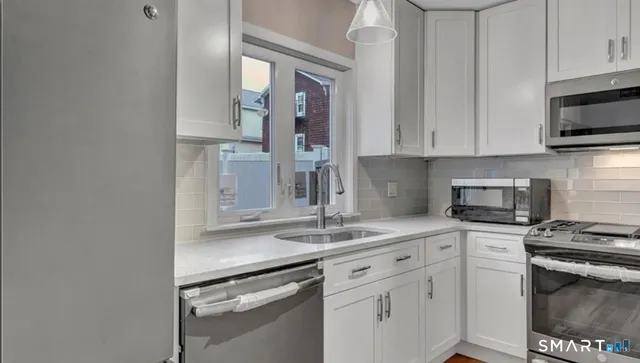 a kitchen with stainless steel appliances granite countertop a sink stove and microwave