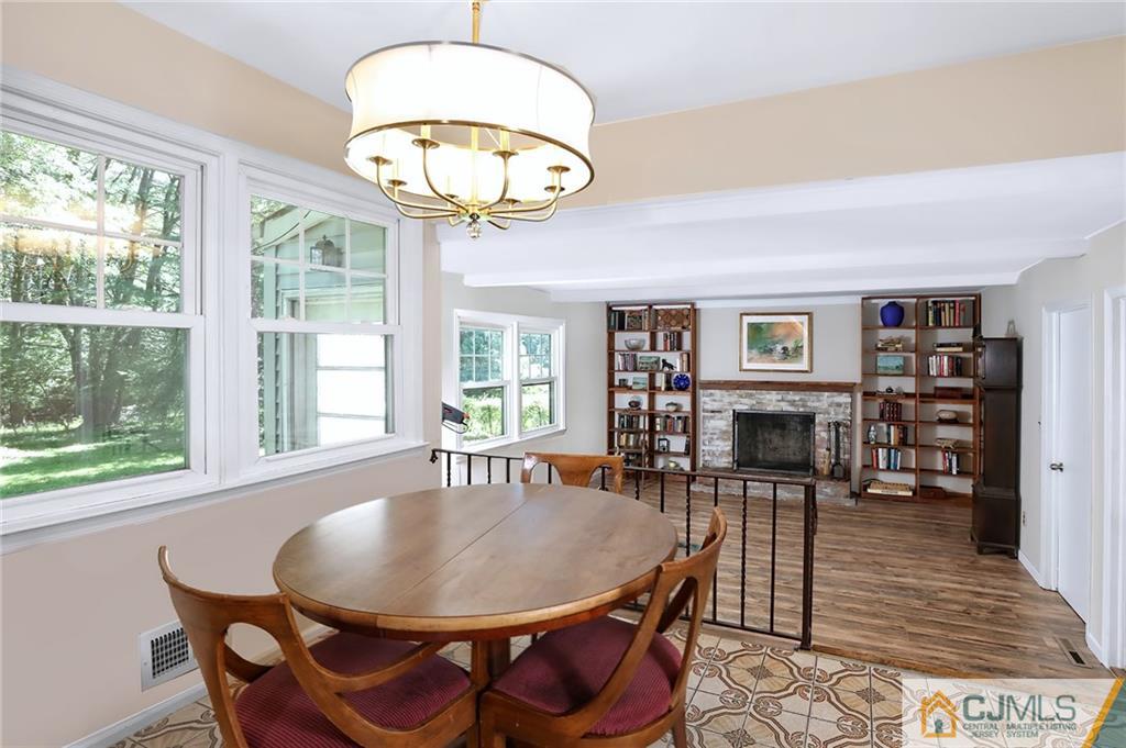 17 Taylor Road Monmouth Junction, NJ 08852 - Photo 12 of 25 a dining room with wooden floor a chandelier a glass table and chairs