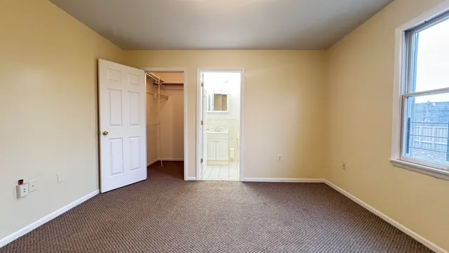 an empty room with windows and closet