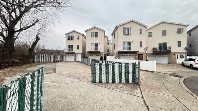 a view of a white house with wooden floor and a fence