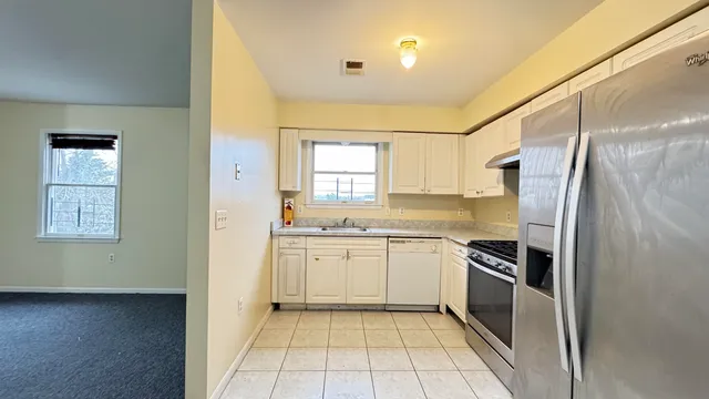 a utility room with dryer washer and a view of kitchen